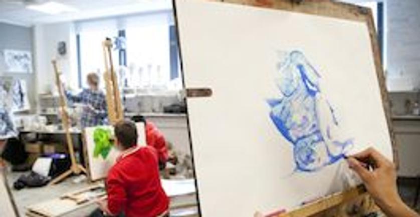A student painting on an easel in an art class, showcasing their creativity and artistic skills.