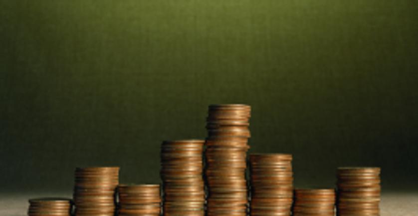 A stack of coins on a green background, symbolizing fees and funding.