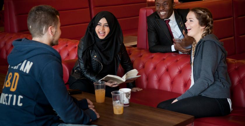 4 students chatting  in a sitting area - there's never a reason to miss out on something happening on campus