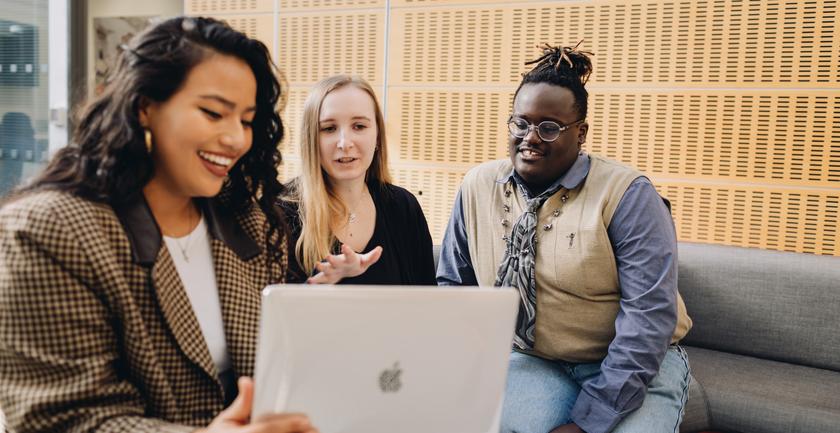Three students looking happy chatting