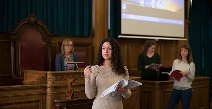 student presents in courtroom-like setting