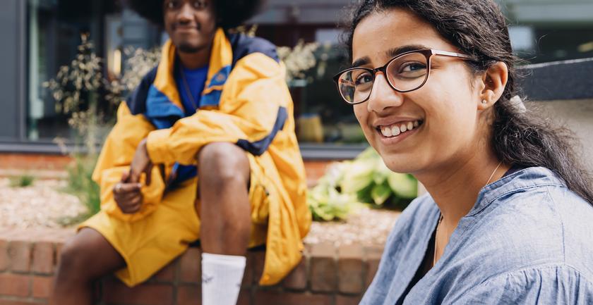 Male and female students sat on campus