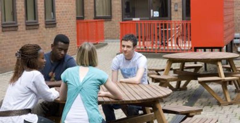 4 students chatting at a table in the courtyard at ivy hall middlesex university