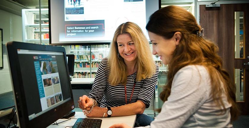 Student using computer help from library support