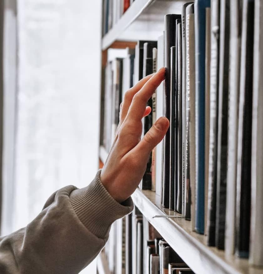 Hand reaching for books