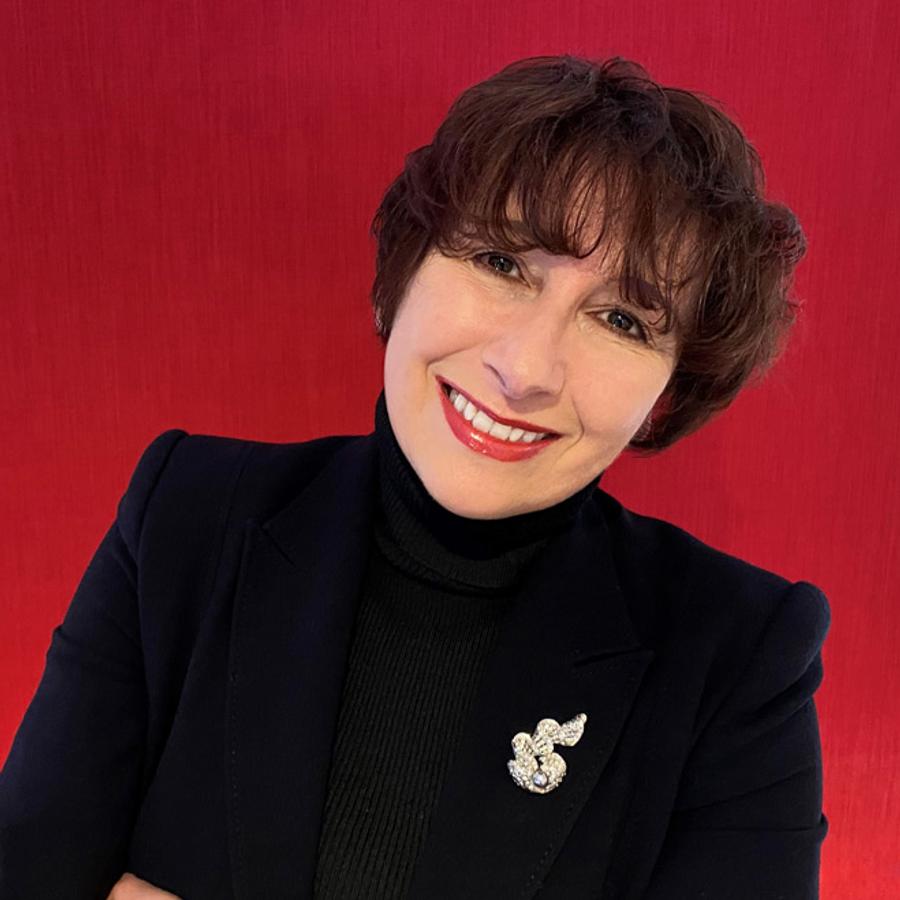 A portrait of Dr Michelle Morgan against a red background