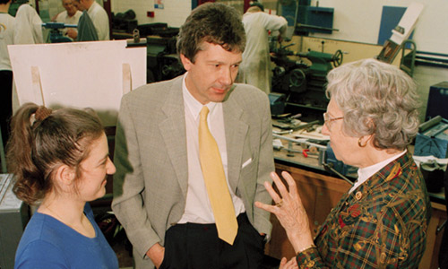 Two females and a male engaged in conversation inside a lab