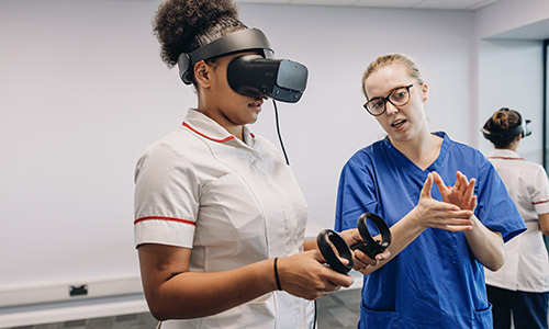 A Nursing student using an AR headset next to an academic in West Stand