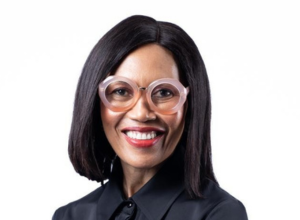 A portrait of Sindi Mabaso-Koyana wearing a black jacket against a white background