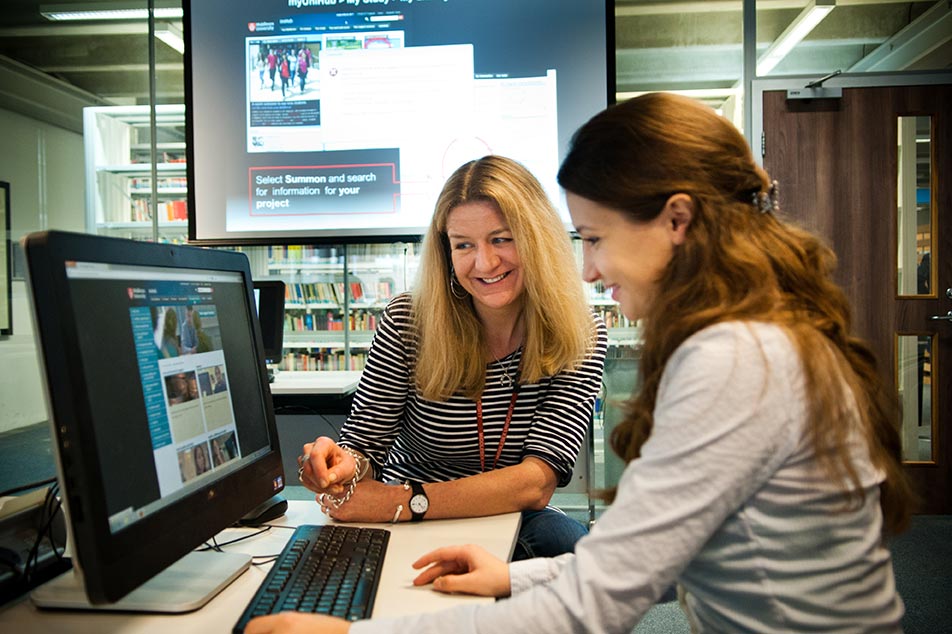 Student using computer help from library support