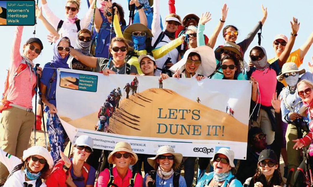 Group of women holding a banner reading let's dune it