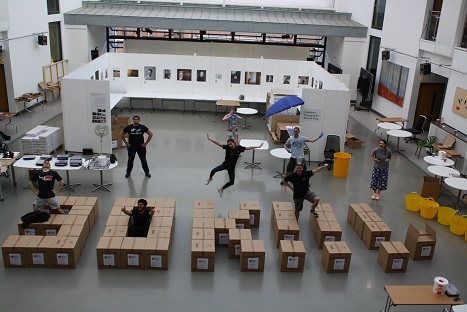 Image of people standing around boxes arranged as '30K', representing Team MDX's effort in creating 60,000 visors for the NHS in six weeks.