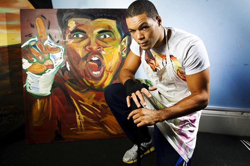 Image of a man proudly displaying a painting of his own likeness.