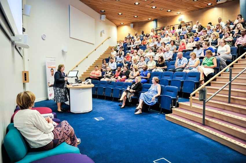 A woman presenting to a large audience