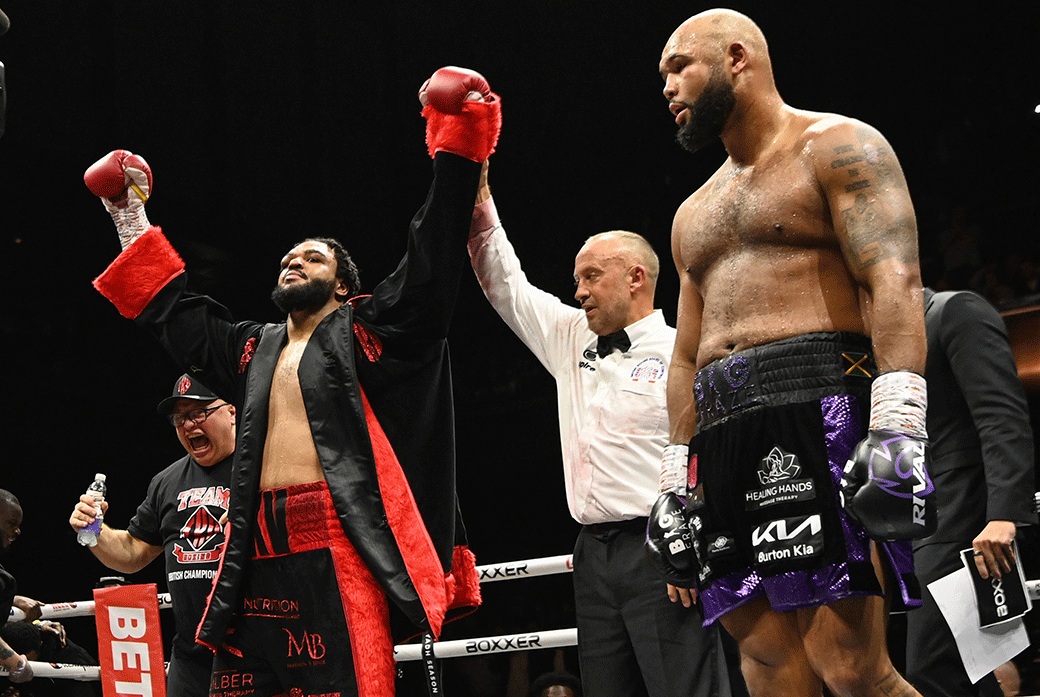 Boxer holds up hands after winning fight