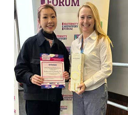 Two women lecturers with a certificate and award
