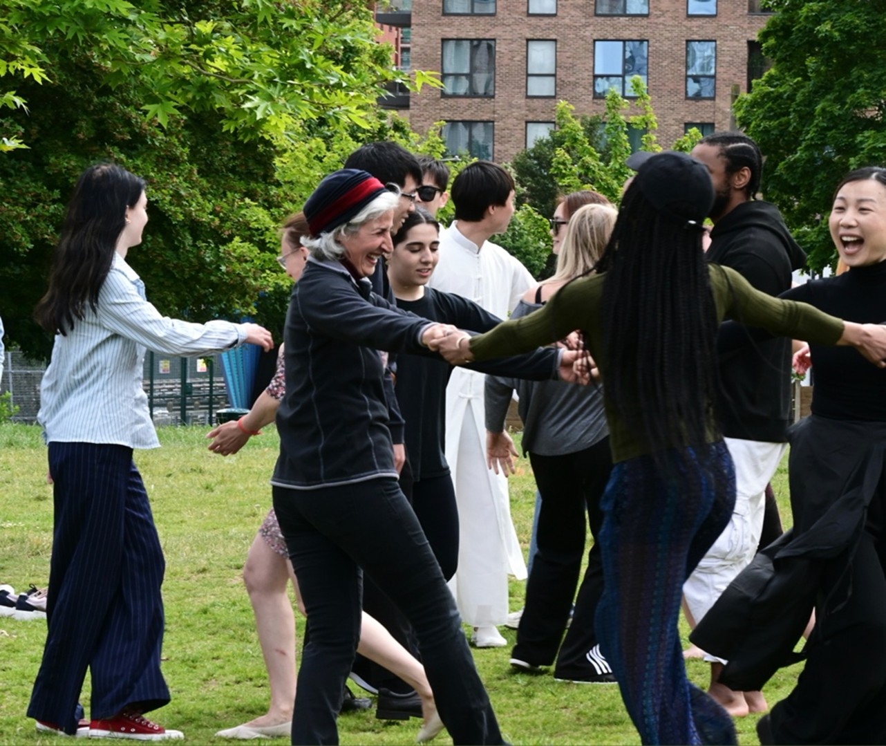 Dancers in black and white costumes mix with audience members/community dancers in a joyful scene