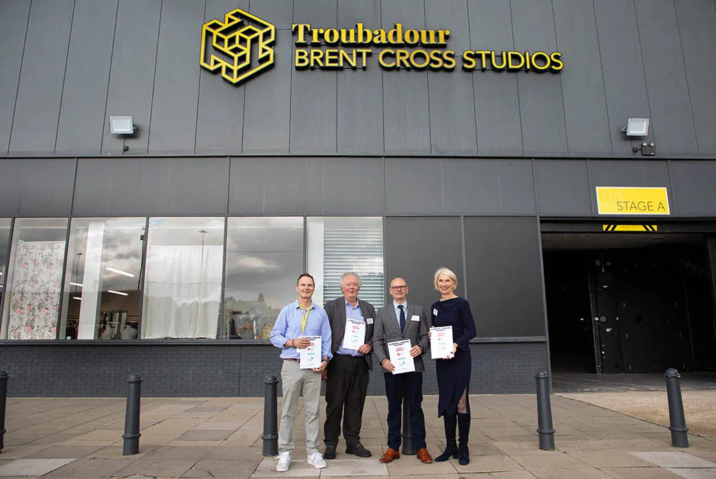 People stand outside building with paper