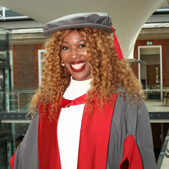 Montell Douglas honorary graduate wearing a graduation robe