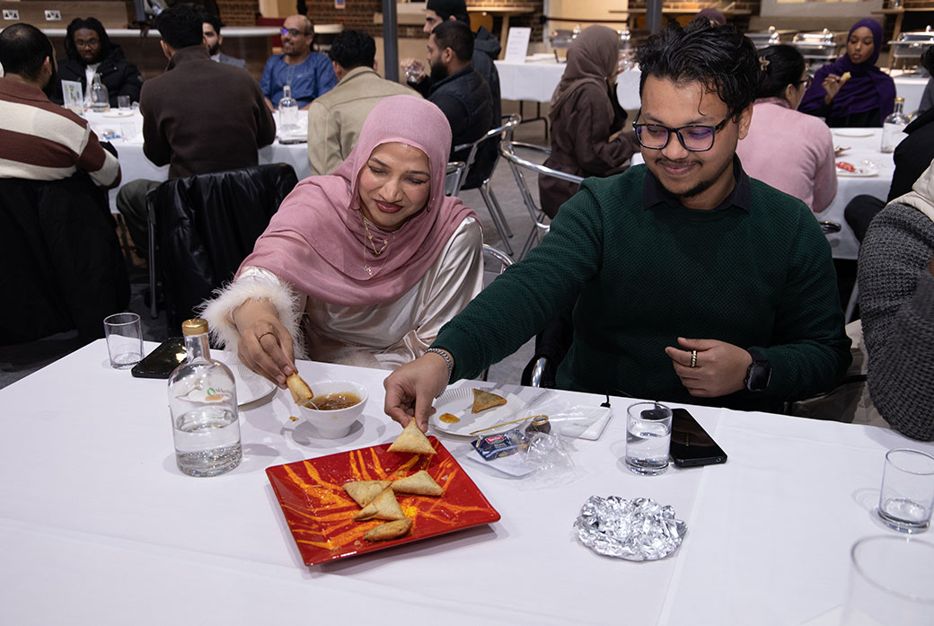 Two brothers sat on table at iftar meal event