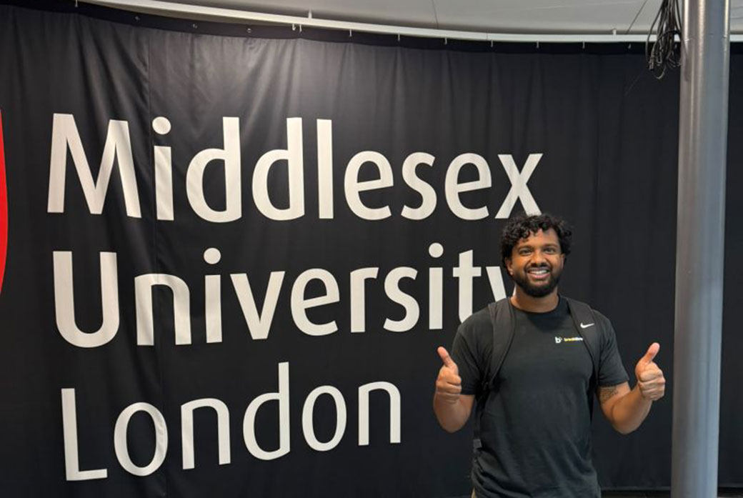 A man stands in front of a sign