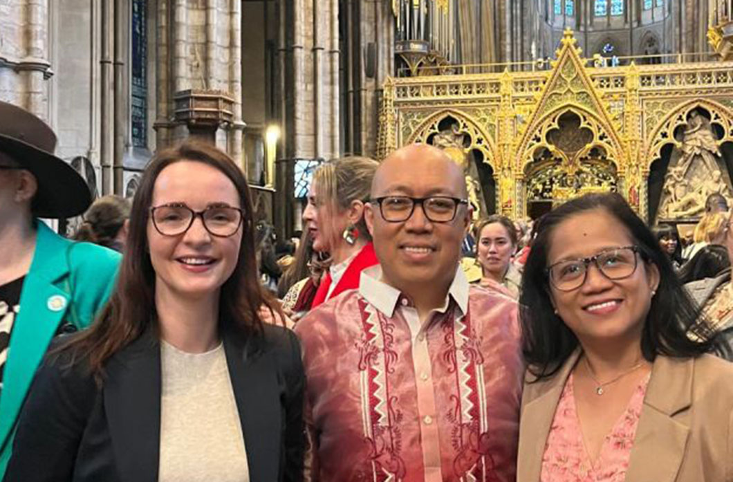Three people look at the camera in an abbey