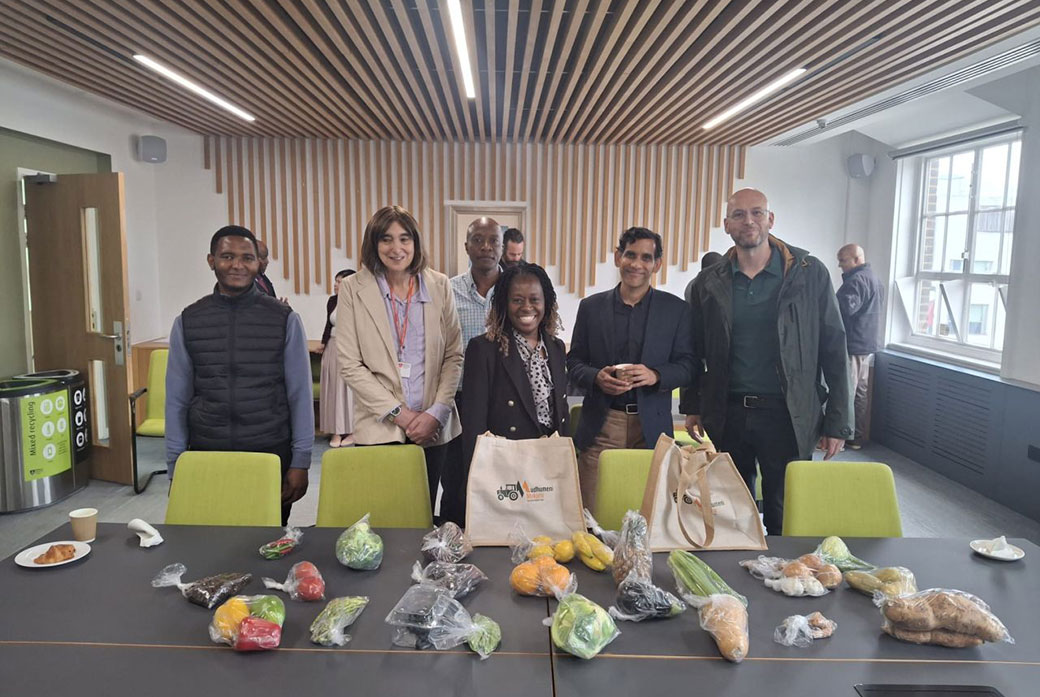 People stand next to a table with food on it