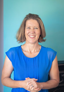 Blonde female with short hair known by the name Debs Wright wearing a blue dress