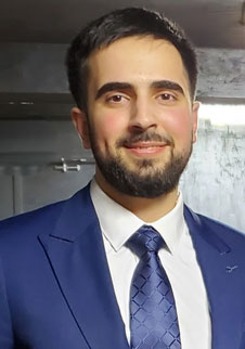 Omer Kacar mdx university alumni wearing a dark blue suit and a tie