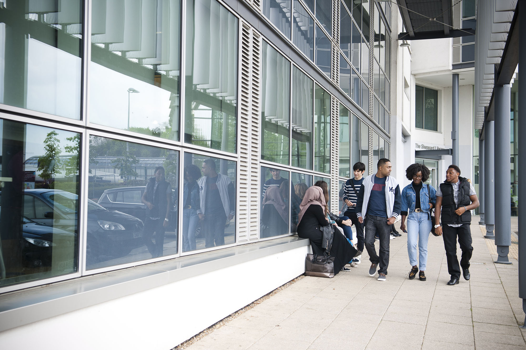 Students walking together outside glass building