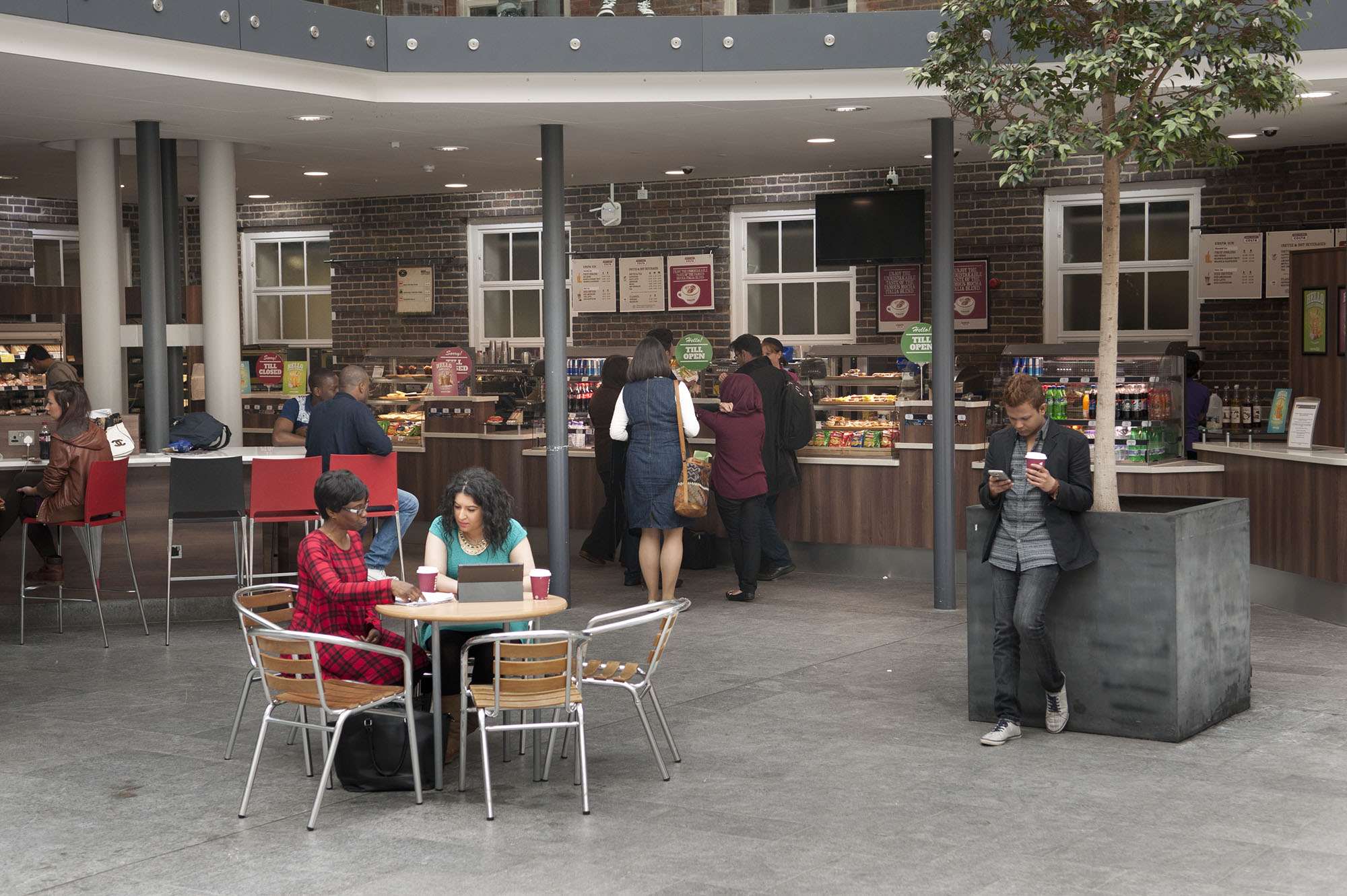 Coffee shop on campus, with some students sitting and others waiting