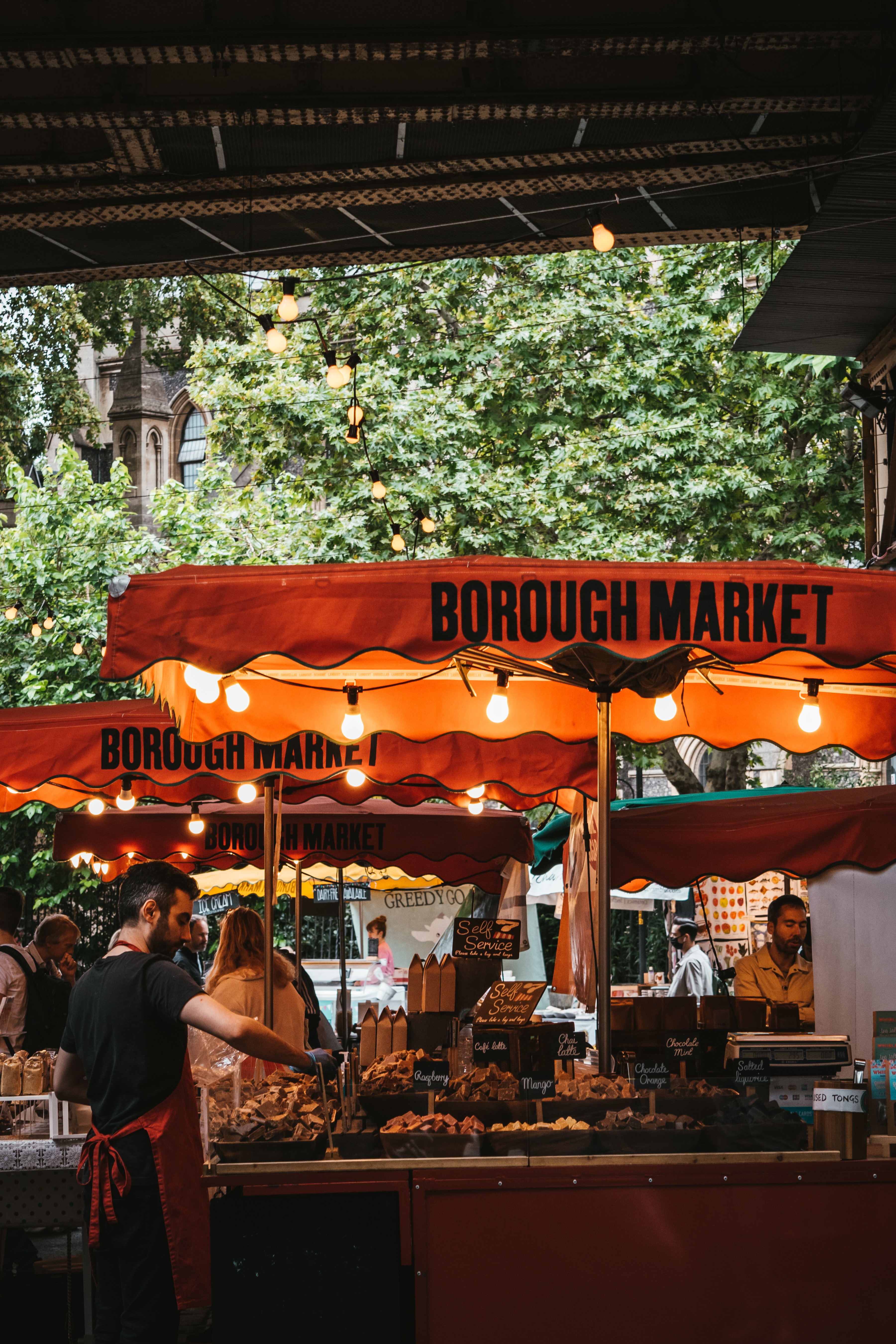 stalls at borough marketing serving hot food under orange canopies