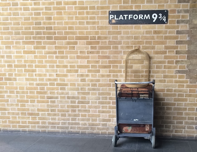 a trolley and an empty bird cage against the wall at platform 9 and three quarters