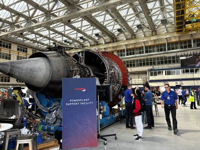 A jet engine on a display stand being looked at by visitors