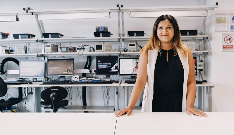Female student stood in front of lab computers.