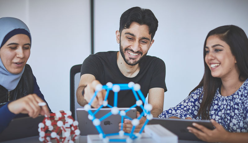 Three students working on a model