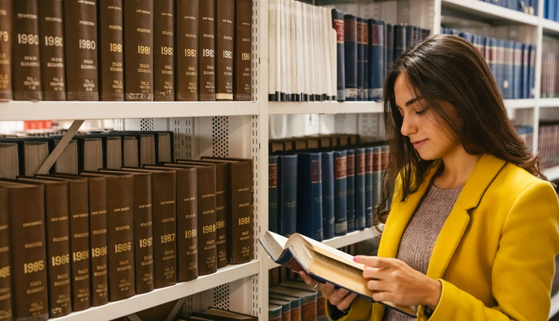 Female law student reading book in library