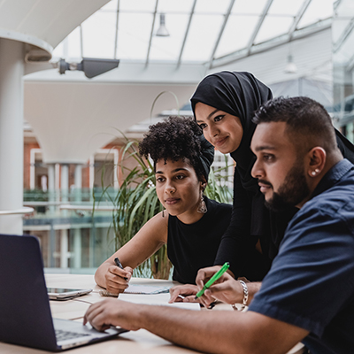 Business and Marketing Students sat at desk looking at laptop