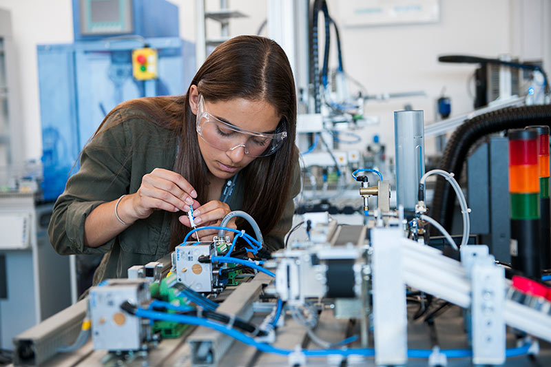 A student operating machinery in a lab.
